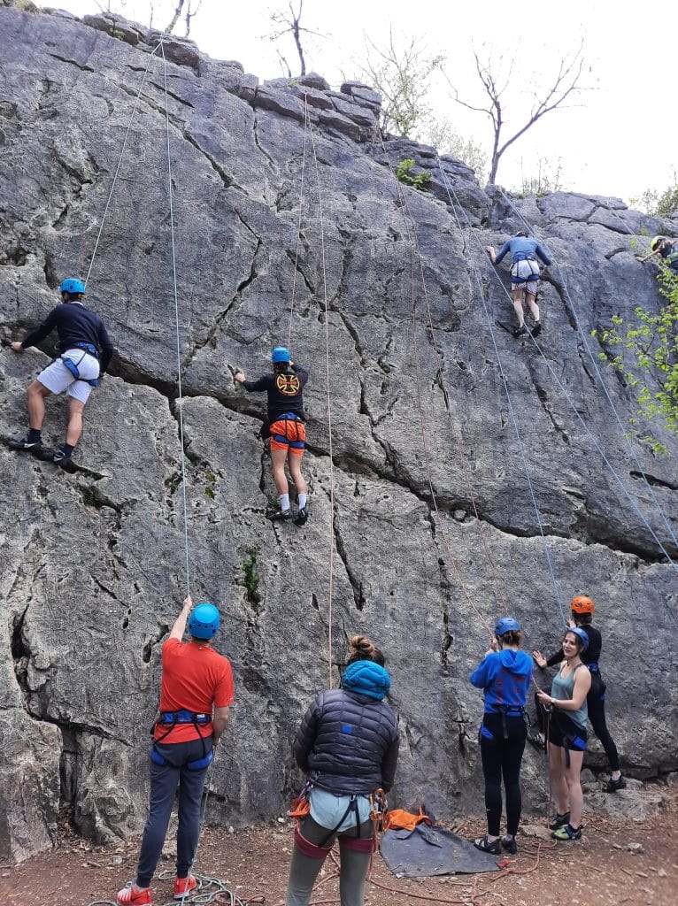 groupe d'adultes font de l'escalade sur des rochers dans les Alpes
